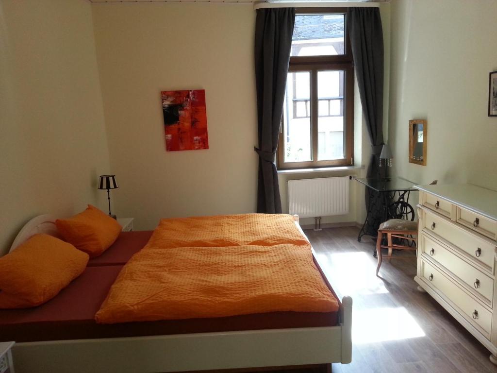 a bedroom with a bed with an orange blanket on it at Bernkastler Graben in Bernkastel-Kues