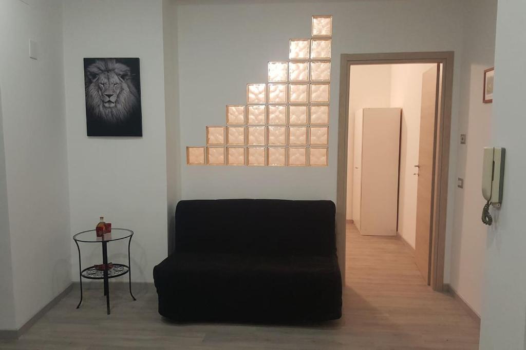ein Wohnzimmer mit einem schwarzen Stuhl und einem Fenster in der Unterkunft Appartamento Martino in Genua