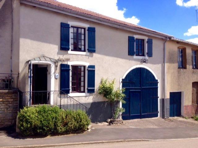 una casa con persianas azules y una puerta azul en Chez Nous, en Isches