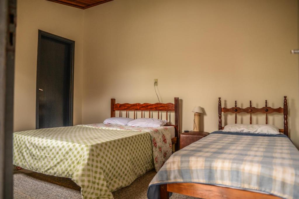 two beds sitting next to each other in a room at Pousada do Tigrinho in São Bento do Sapucaí