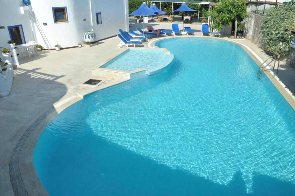 una gran piscina azul con tumbonas azules. en Bodrum Blu Hotel, en Bodrum City