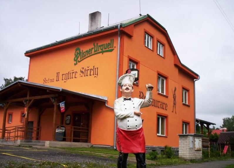 una estatua de un chef parado frente a un edificio en Penzion Střela Krucemburk, en Křížová