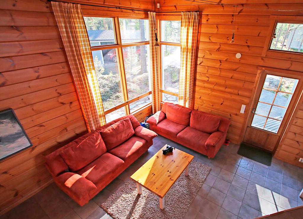 a living room with two red couches and a table at Oravi Villas in Oravi