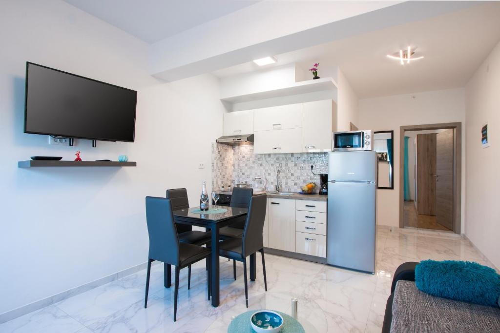kuchnia i jadalnia ze stołem i lodówką w obiekcie Apartment Rnjak w mieście Vinkuran
