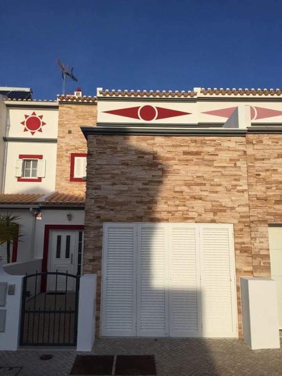 a building with a garage with a large pizza sign on it at Beachouse Algarve in Manta Rota