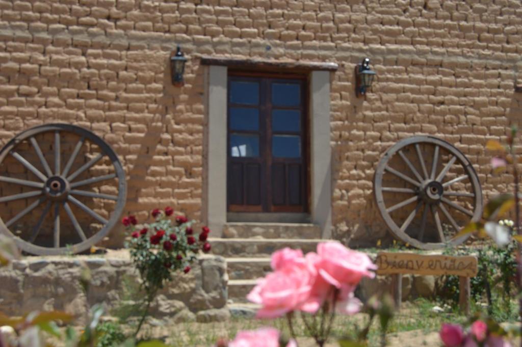 un edificio con dos ruedas dobladas delante de una puerta en Finca Las Pircas Casa de Adobe, en Famatina