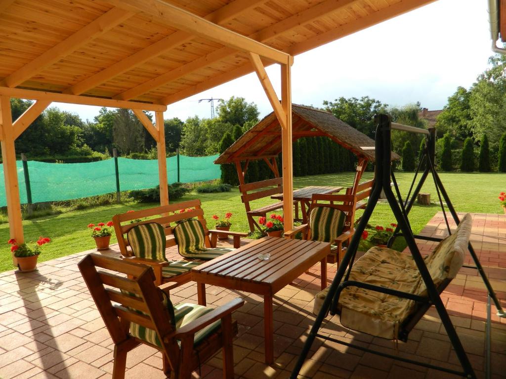 - un patio avec une table et des chaises en bois sous un pavillon dans l'établissement Villa Maria, à Egerszalók