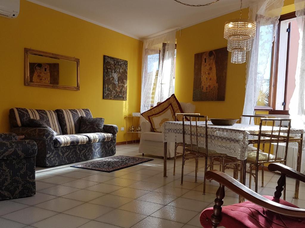 a living room with yellow walls and a table and chairs at Moro Dal Castel - Appartamento Al Castel in Castelnuovo del Garda