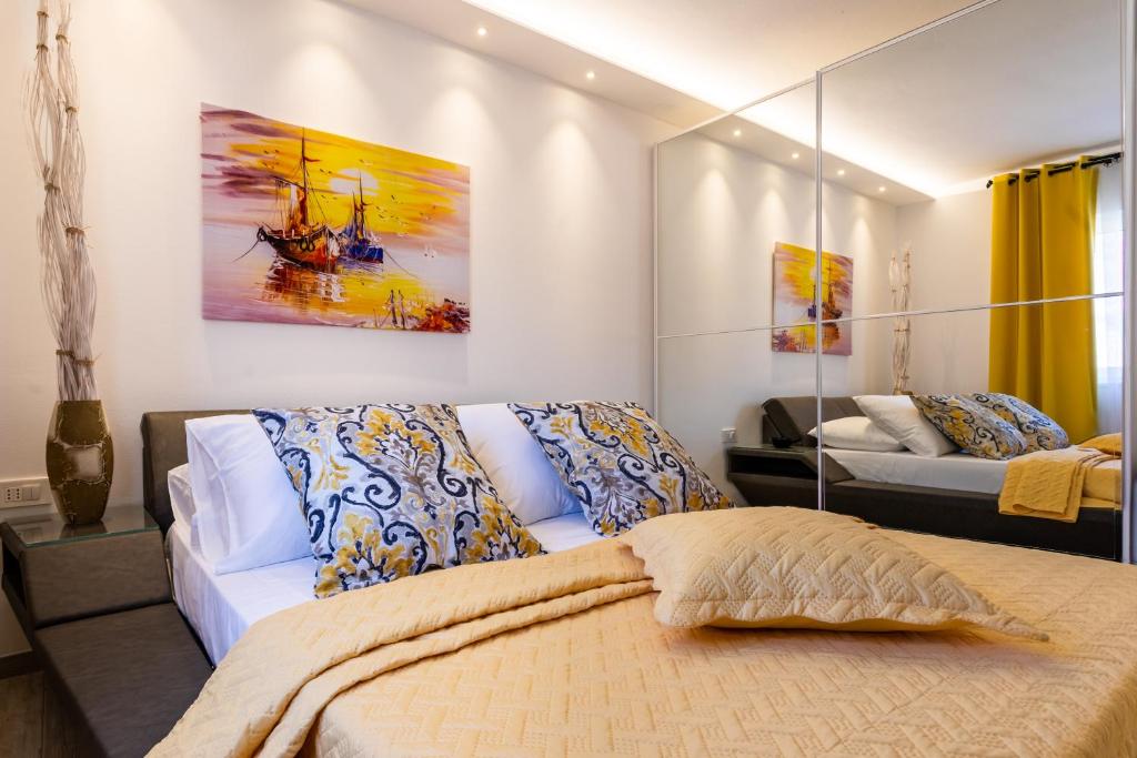 a bedroom with a bed and a couch and paintings at Villa Valis in Baška