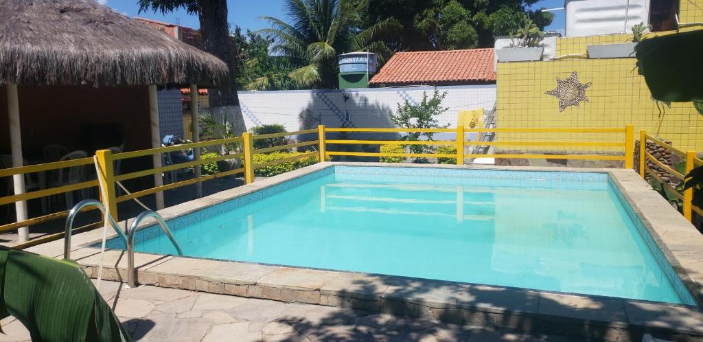 ein Schwimmbad mit einem gelben Zaun um ihn herum in der Unterkunft Itaparica - Vera Cruz 12 pessoas in Vera Cruz de Itaparica