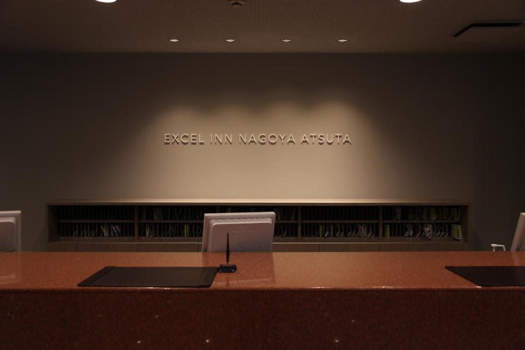 a desk in a room with a sign on the wall at Excel Inn Nagoya Atsuta in Nagoya