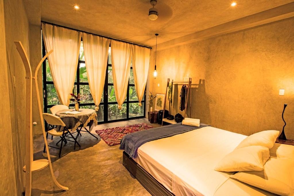 a bedroom with a bed and a table and a window at Kapievi Ecovillage in Puerto Maldonado