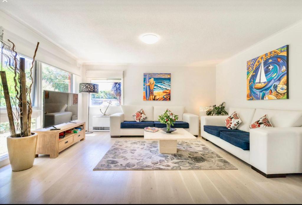 a living room with a couch and a table at By The Beach Frankston in Frankston