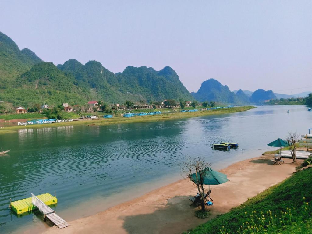 a body of water with mountains in the background at Oxalis Home in Phong Nha