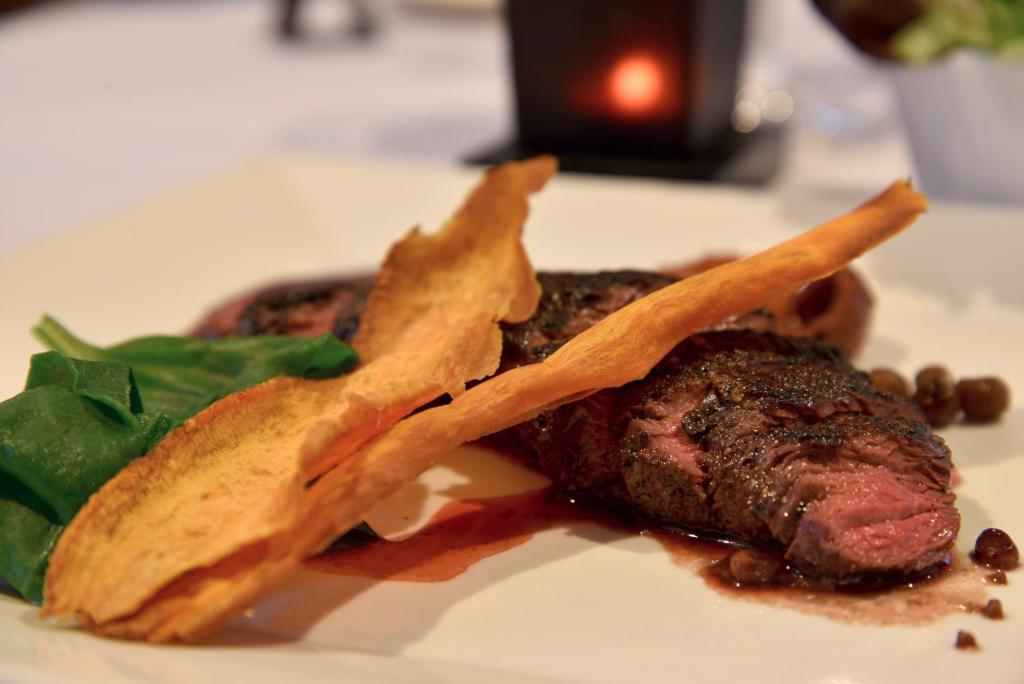 een bord eten met een stuk vlees en chips bij Burra Motor Inn in Burra