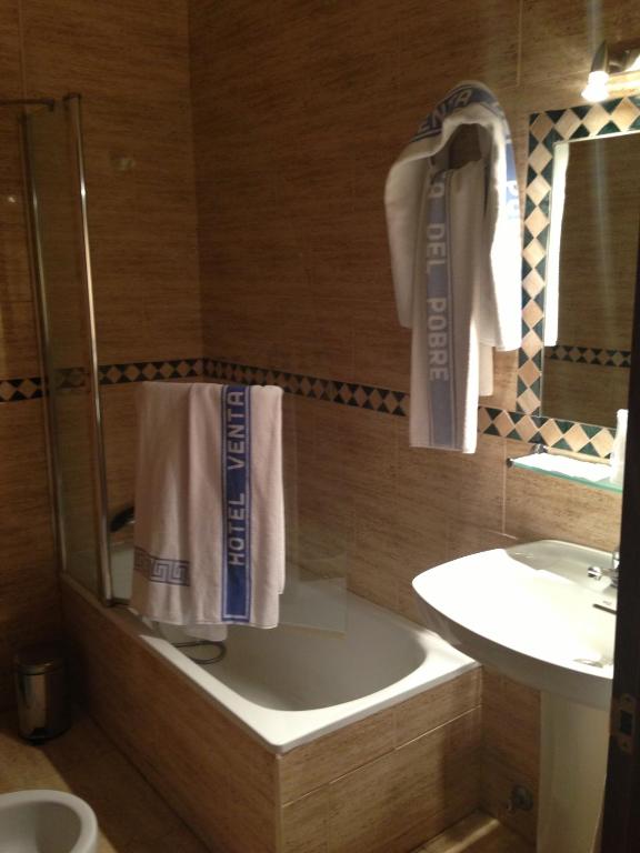 łazienka z prysznicem, umywalką i ręcznikami w obiekcie Hotel Venta del Pobre w mieście Níjar