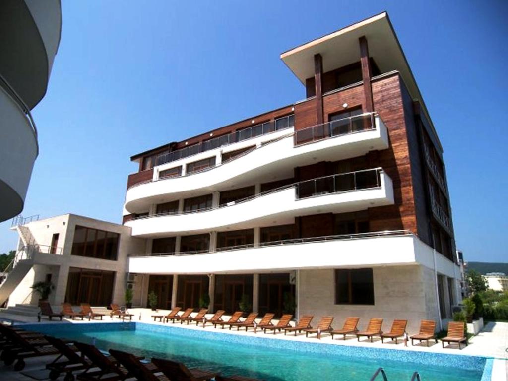 a building with a swimming pool next to a hotel at Eden - Menada Apartments in Sunny Beach