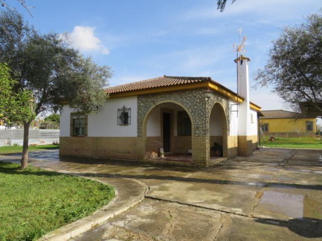 Una pequeña iglesia con una cruz encima. en CHalet aeropuerto Sevilla en Sevilla