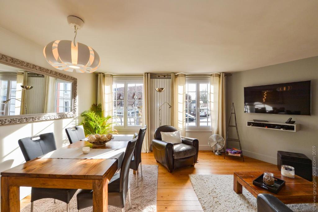 uma sala de estar com uma mesa de jantar e cadeiras em La Maison de Pierre et Valérie Ste Catherine Honfleur em Honfleur