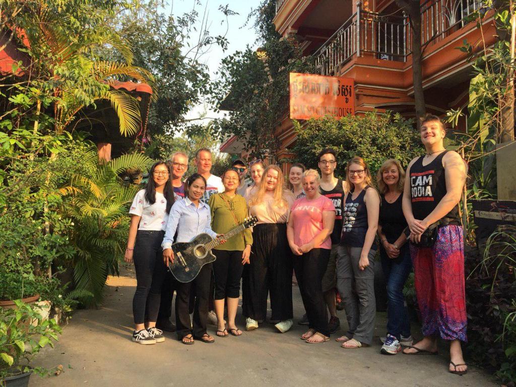 un grupo de personas posando para una foto frente a una casa en Sam So Guesthouse, en Siem Reap