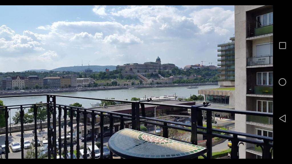 a balcony with a view of a river and buildings at Jackquaters in Budapest