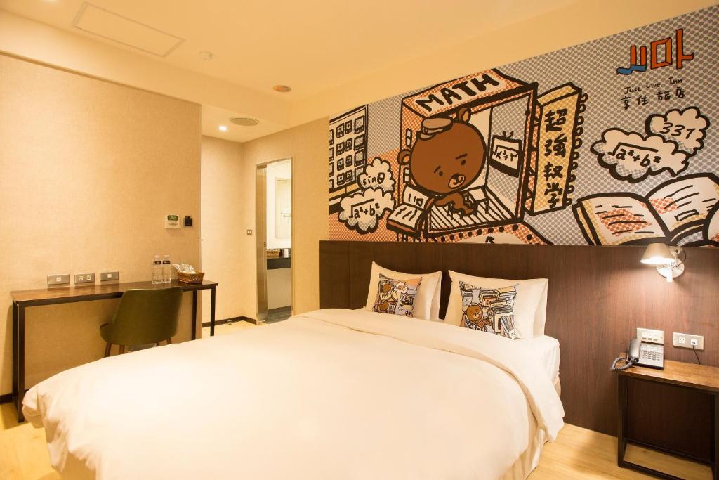 a bedroom with a large bed and a wall with stickers at Just Live Inn-Taipei Station in Taipei
