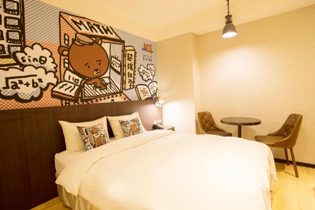 a bedroom with a large bed with a painting on the wall at Just Live Inn-Taipei Station in Taipei