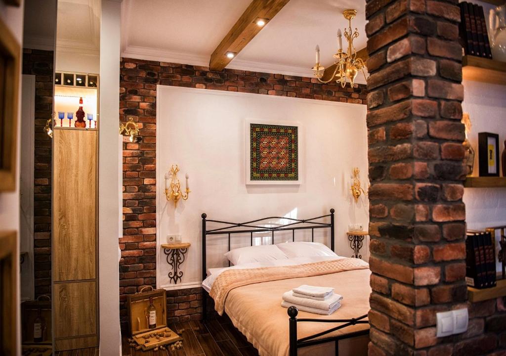 Schlafzimmer mit Ziegelwand und Bett in der Unterkunft Vinodorum Apartments in Chişinău