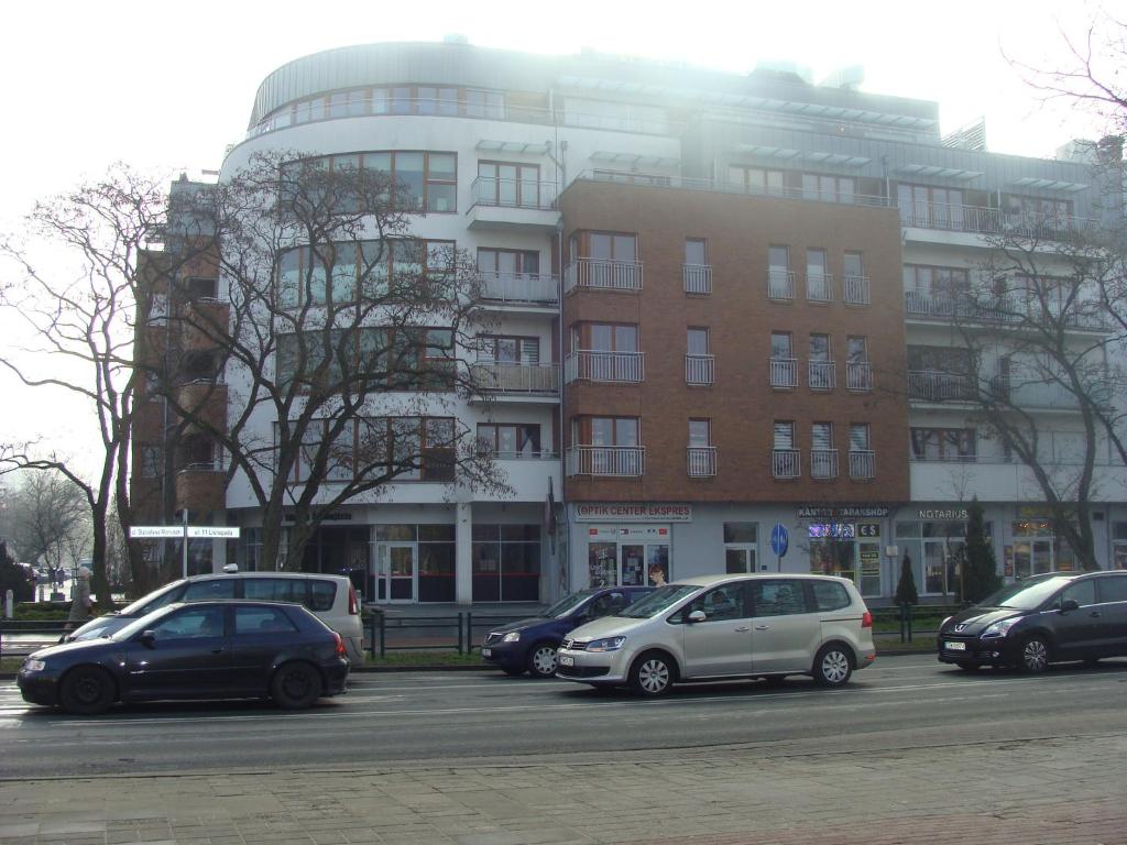 a parking lot with cars parked in front of a building at Świnoujscie-Platan in Świnoujście