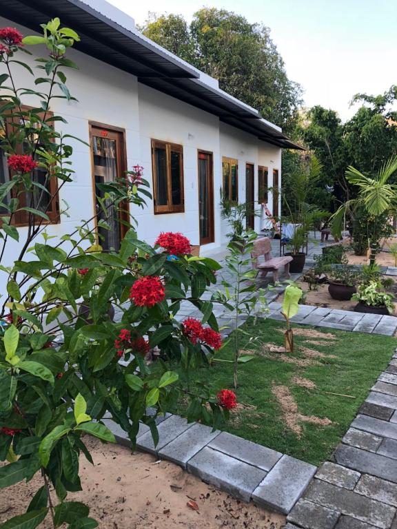 a house with red flowers in front of it at Bí Homestay in Mui Ne