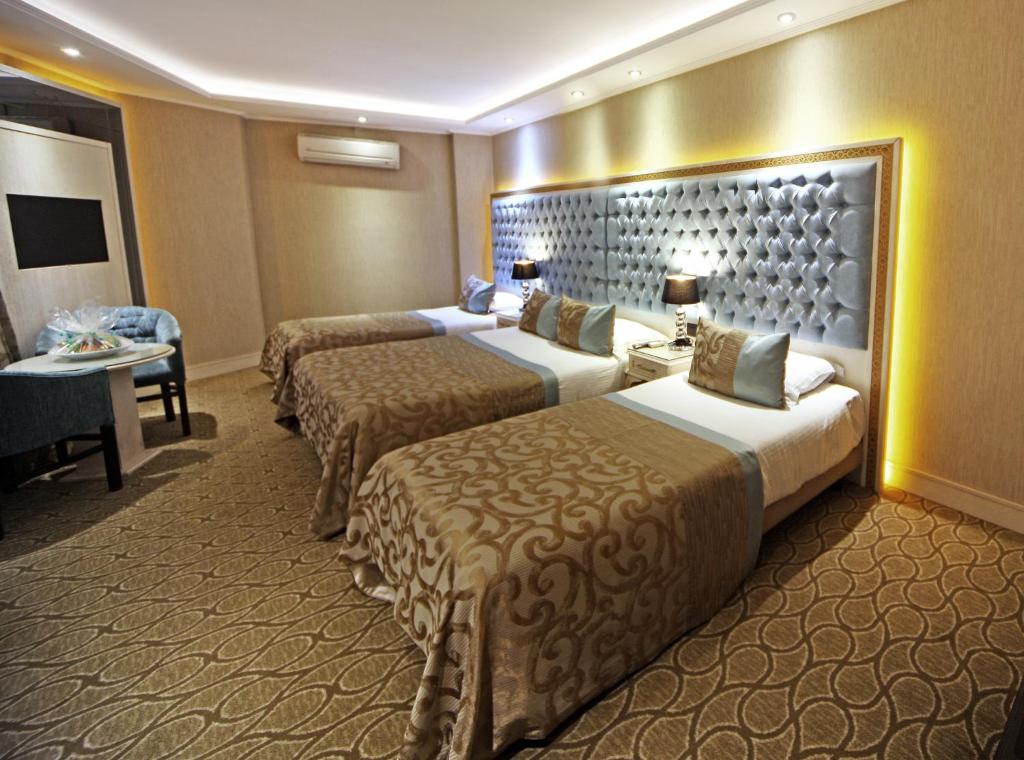 une chambre d'hôtel avec deux lits et une table dans l'établissement The Parma Hotel Downtown, à Istanbul