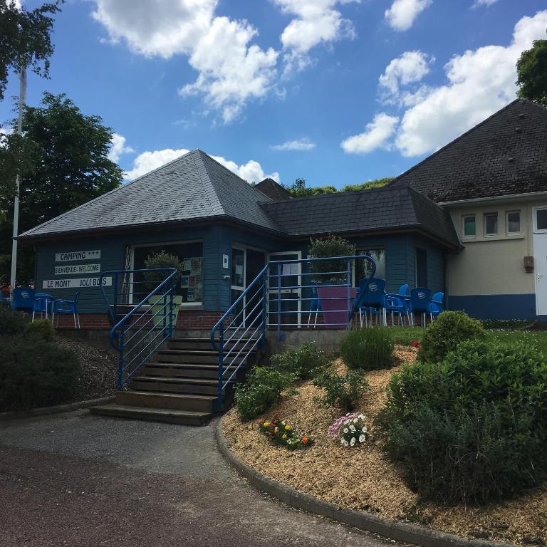 une maison bleue avec des chaises bleues devant elle dans l'établissement Camping le Mont Joli Bois, à Criel-sur-Mer