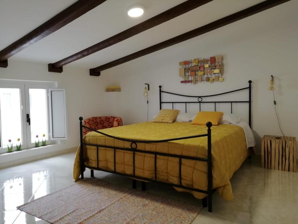a bedroom with a large bed in a room with white walls at Antiche Mura Apartments"Cielo di Puglia" -2 matrimoniali, cucina,letto singolo e terrazzo in Turi