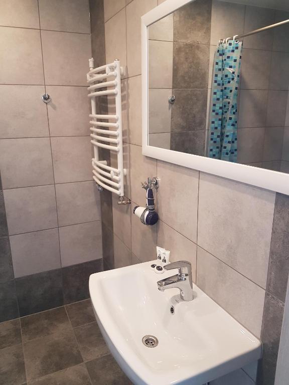 a bathroom with a sink and a mirror at Noclegi u Andrzeja in Gdańsk