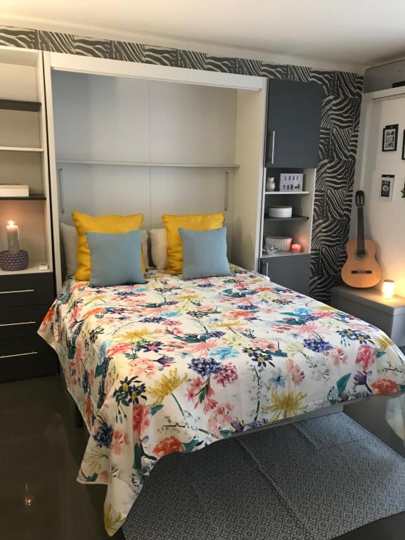 um quarto com uma cama com colcha floral em République n°1 em Beausoleil