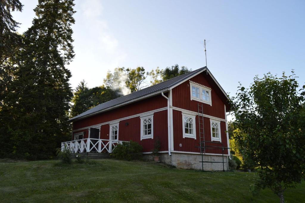 a red barn sitting on top of a lush green field at Leipyölin tila in Perniö