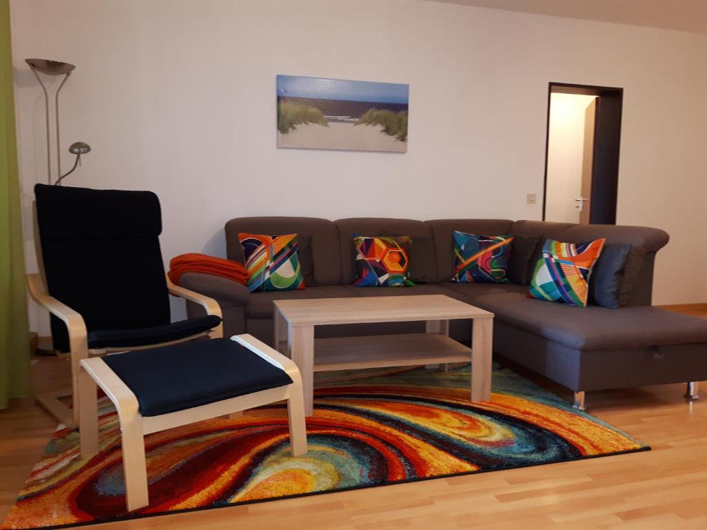 ein Wohnzimmer mit einem Sofa und einem Stuhl in der Unterkunft Ferienwohnung Schiffsblick Horumersiel in Wangerland
