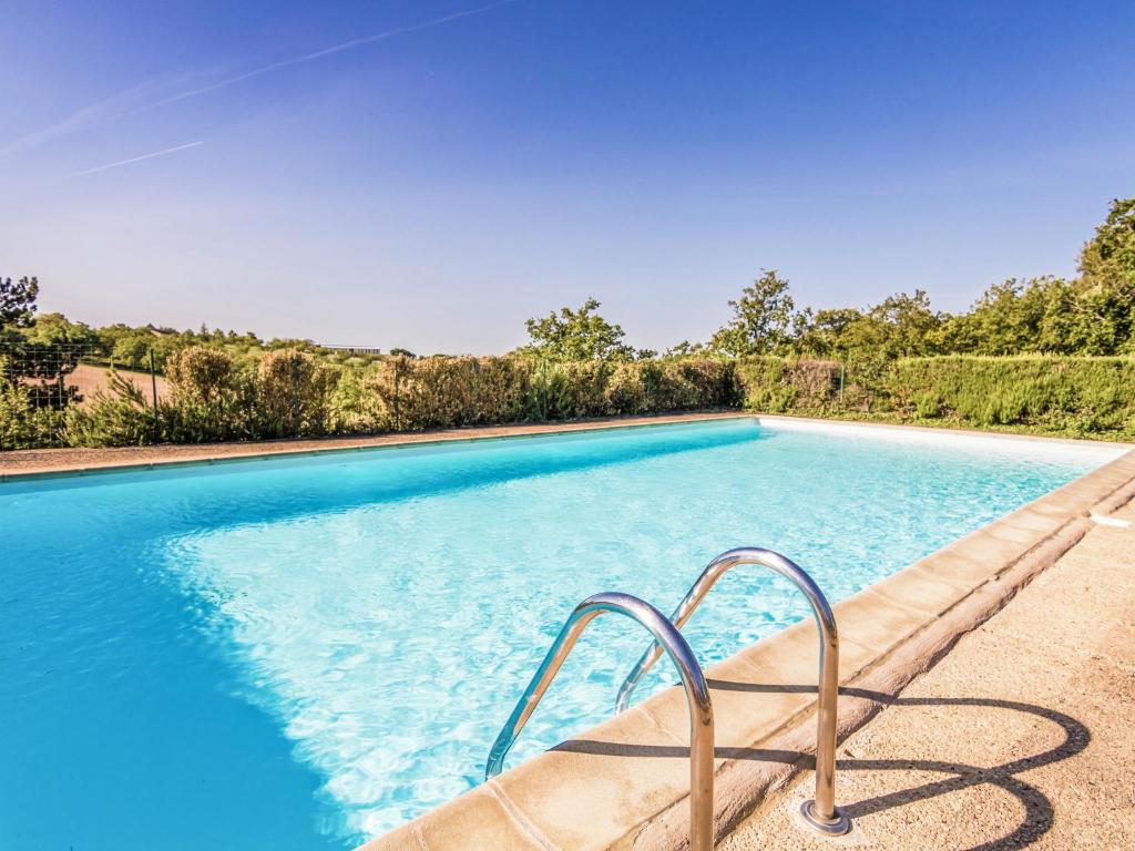 una piscina blu con corrimano di metallo accanto di Holiday home with swimming pool a Salignac