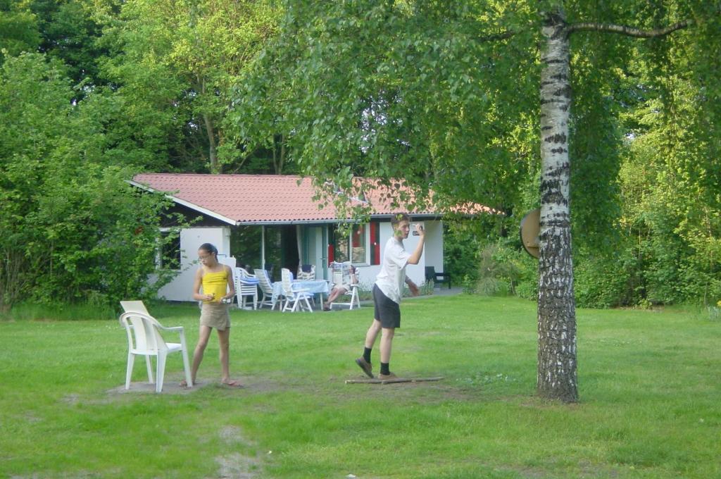 dos personas jugando con un frisbee en un patio en Vakantiebungalow Oase en Exloo