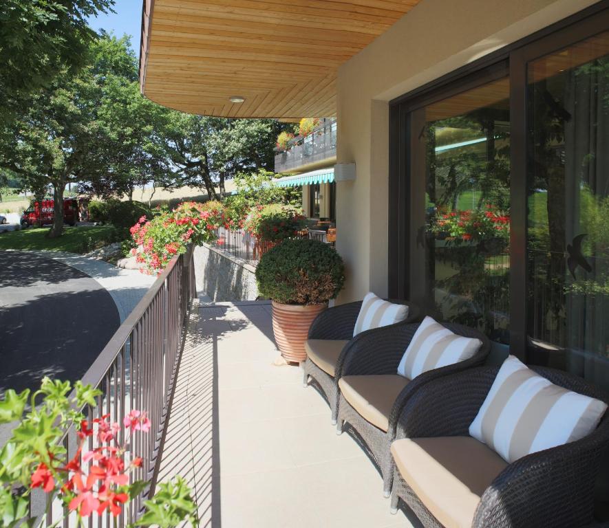 a row of benches on a balcony with flowers at Auberge Sundgovienne in Carspach