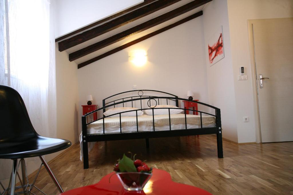 een slaapkamer met een bed in de hoek van een kamer bij Rooms Beljan in Trogir