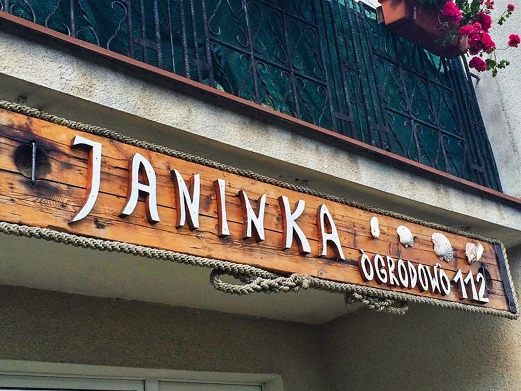 a sign on the side of a building at Pokoje i Domki Gościnne Janinka in Jastarnia