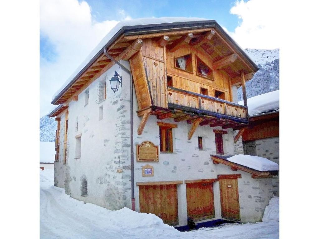 a cabin in the snow with a balcony at Wooden chalet in Paradiski ski area in Le Villard