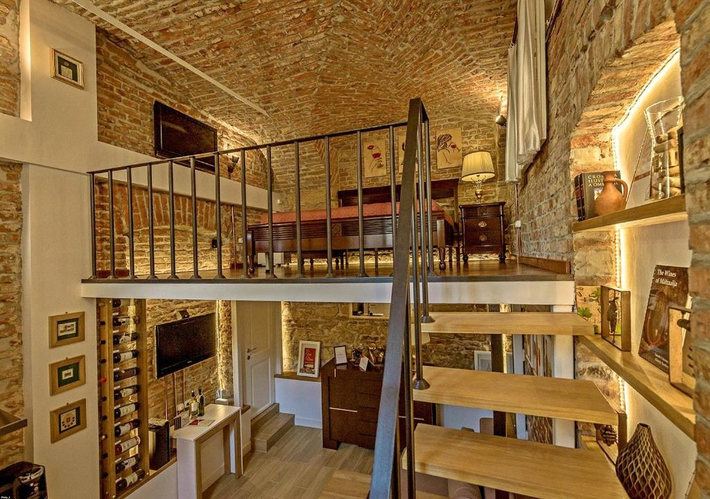 - un escalier dans une pièce dotée d'un mur en briques dans l'établissement Vinodorum Apartments, à Cluj-Napoca
