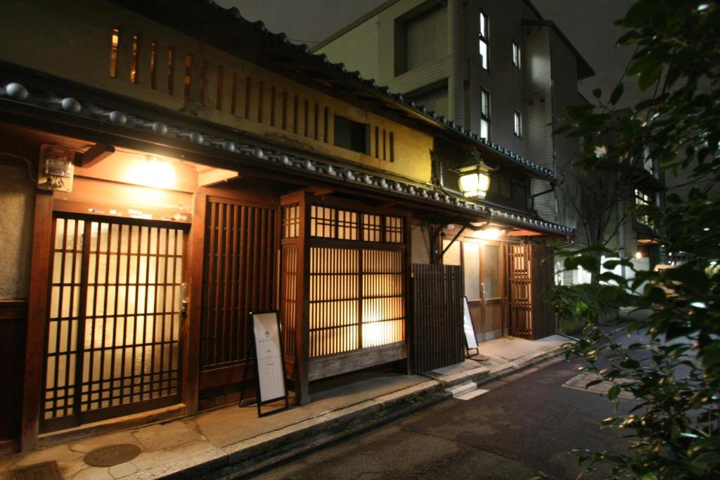 a building with a gate on a street at night at HARUYA Umekoji in Kyoto