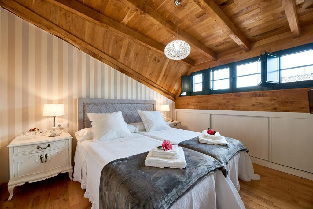 ein Schlafzimmer mit einem großen Bett mit Handtüchern darauf in der Unterkunft Casa Entera A Ferradura in Melide