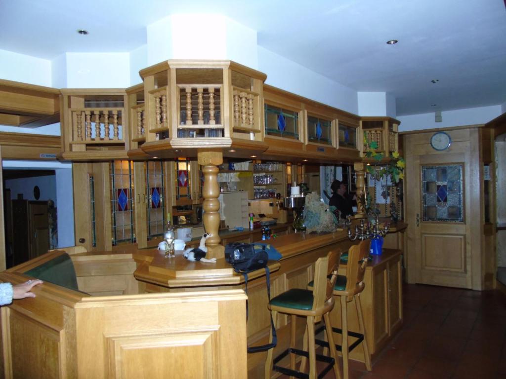 a large room with a bar with wooden cabinets at Hotel Haus Irsfeld in Waxweiler