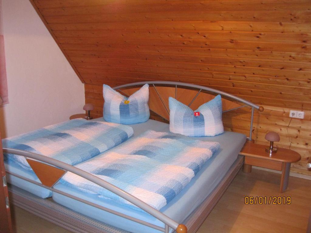 Bett mit blauen und weißen Kissen in einem Zimmer in der Unterkunft Ferienwohnung Anna in Maroldsweisach