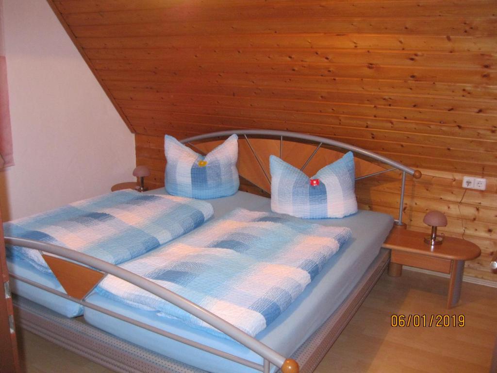 a bed with blue and white pillows in a room at Ferienwohnung Anna in Maroldsweisach