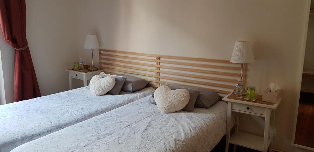 um quarto com duas camas com almofadas em La casa de Maria em San Sebastián